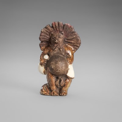 Lot 485 - WAHEI: AN AMUSING CERAMIC NETSUKE OF A TANUKI DISGUISED AS A SAKE VENDOR
