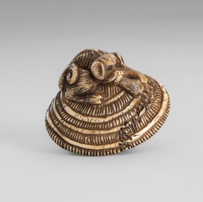 Lot 1696 - AN ANTLER NETSUKE OF A DOG ON A STRAW HAT