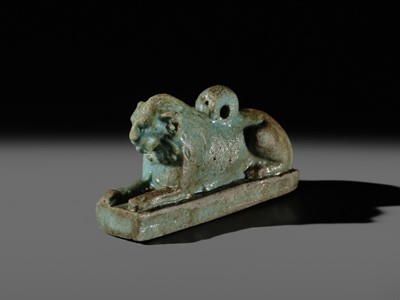 Lot 52 - A TURQUOISE-GLAZED FAIENCE AMULET OF A RECUMBENT LION, LATE PERIOD