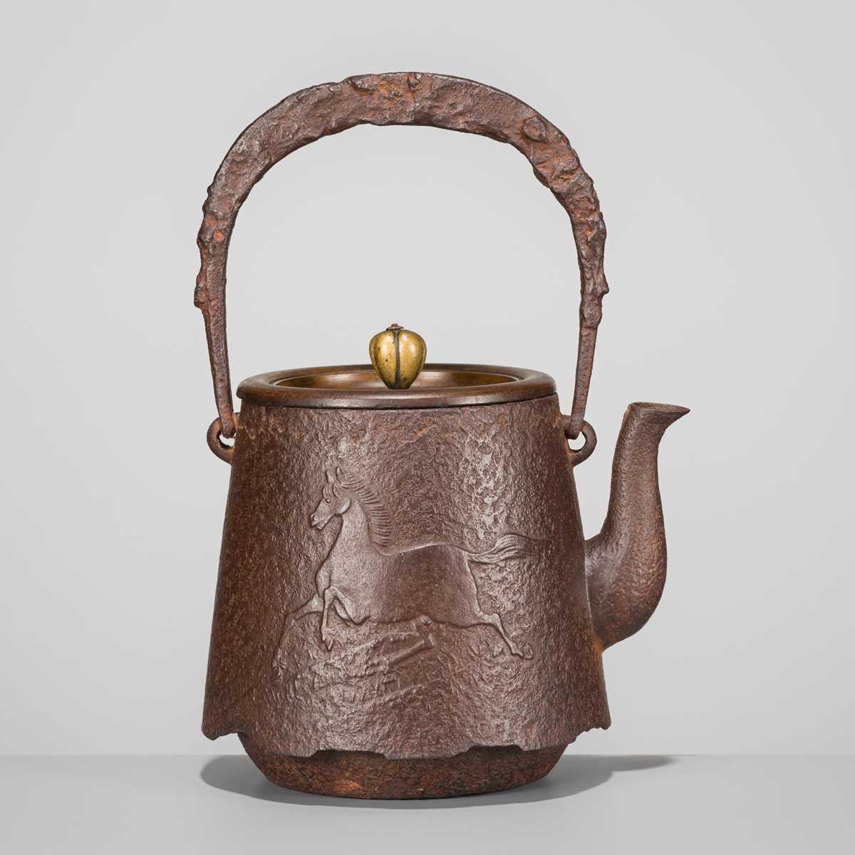 Lot 34 - SEISUKE: AN IRON TETSUBIN (TEA KETTLE) WITH GALLOPING HORSE