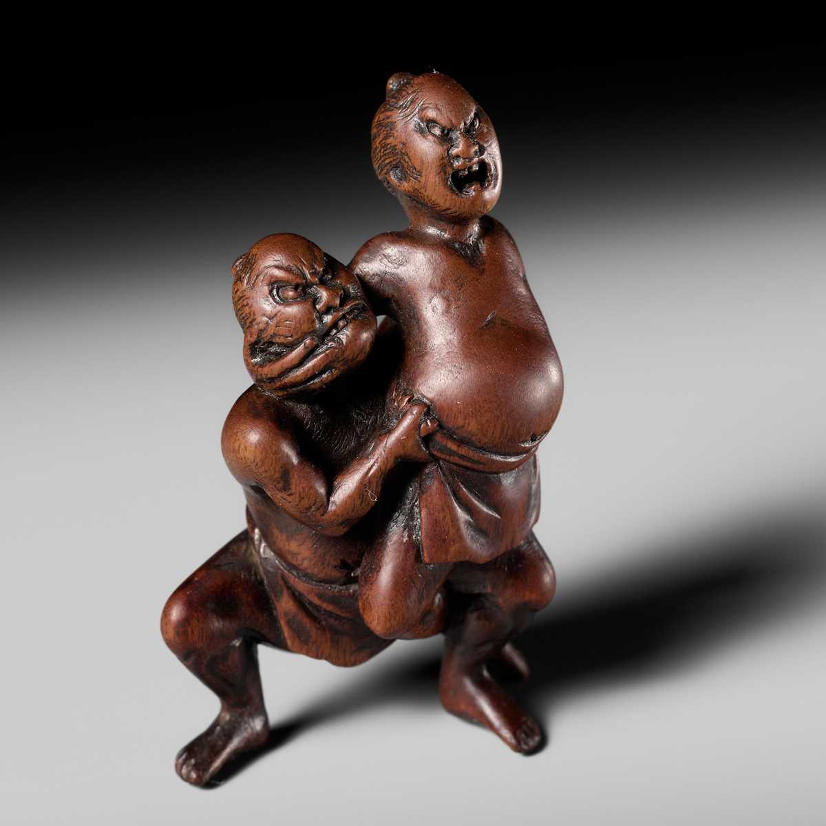Lot 194 - ITTAN: A WOOD NETSUKE OF TWO SUMO WRESTLERS