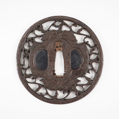 Lot 1834 - UMETADA: A FINE IRON SUKASHI TSUBA WITH A TWO-PRONGED DAIKON