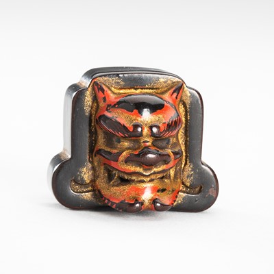 Lot 1736 - A SIGNED NEGORO LACQUER NETSUKE DEPICTING A ROOF TILE WITH ONI MASK