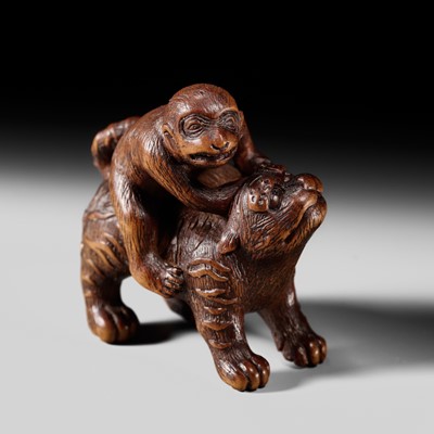 Lot 138 - DORAKU: A RARE EARLY OSAKA SCHOOL WOOD NETSUKE OF A MONKEY AND TIGER