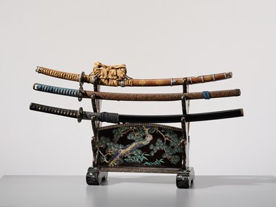 Lot 135 - A SUPERB MOTHER-OF-PEARL INLAID AND BLACK-LACQUERED ‘THREE FRIENDS OF WINTER (SHOCHIKUBAI)’ KATANA-KAKE (SWORD STAND)