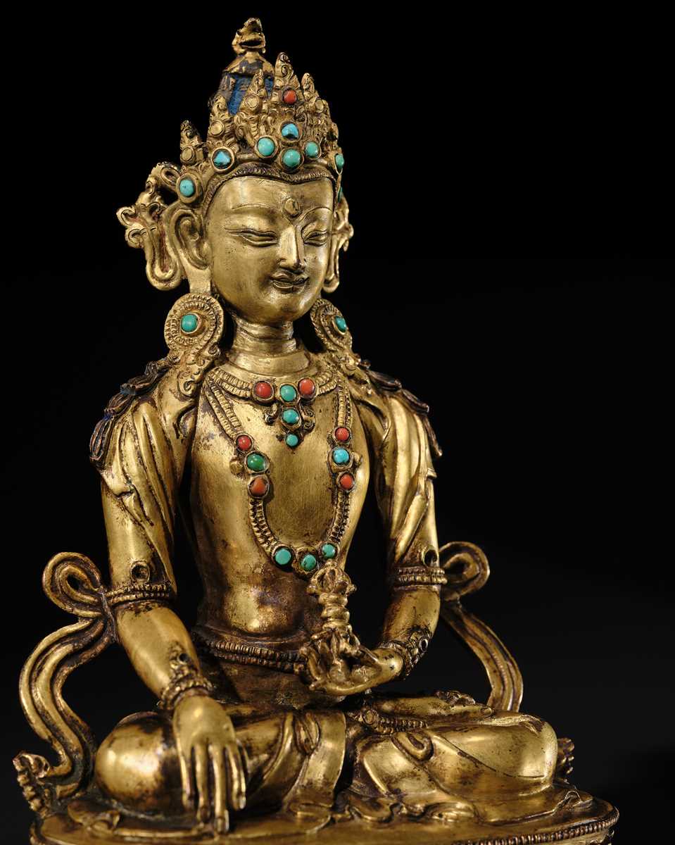 Lot 17 - AN INLAID GILT-BRONZE FIGURE OF AKSHOBHYA, TIBET, 16TH-17TH CENTURY