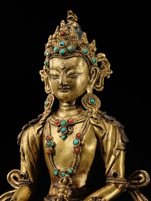 Lot 17 - AN INLAID GILT-BRONZE FIGURE OF AKSHOBHYA, TIBET, 16TH-17TH CENTURY
