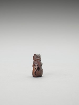 Lot 323 - A CHARMING TOKYO SCHOOL WOOD NETSUKE OF A CAT WITH A BALL