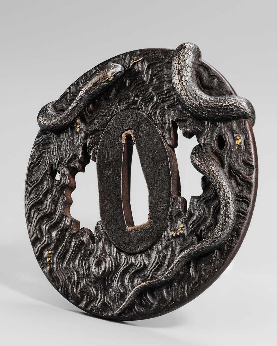 Lot 55 - IWAMOTO RYOKAN: A FINE IWAMOTO SCHOOL IRON TSUBA OF A SNAKE ON A TRUNK