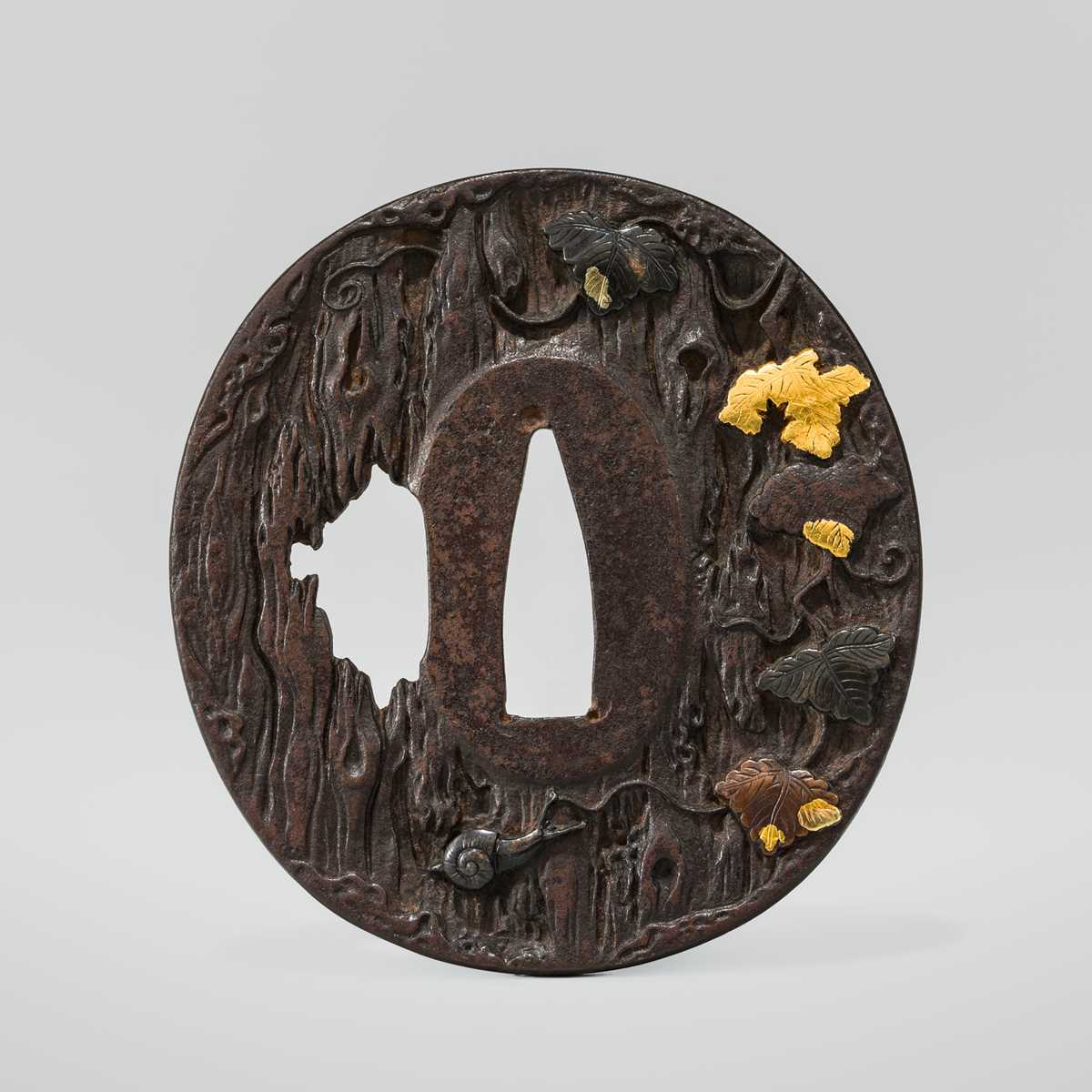 AN IRON HAMANO SCHOOL TSUBA DEPICTING A SNAIL ON AN OLD TREE, WITH HOZON TOSOGU NBTHK CERTIFICATE