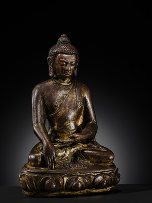 Lot 12 - AN INCSCRIBED GILT-COPPER FIGURE OF BUDDHA SHAKYAMUNI, NEPAL, LATE 13TH-EARLY 14TH CENTURY