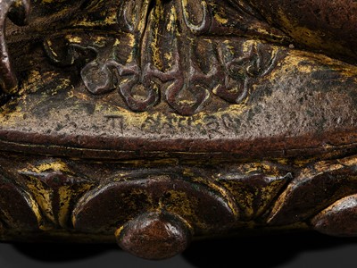 Lot 12 - AN INCSCRIBED GILT-COPPER FIGURE OF BUDDHA SHAKYAMUNI, NEPAL, LATE 13TH-EARLY 14TH CENTURY