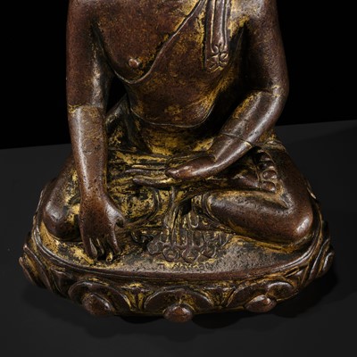 Lot 12 - AN INCSCRIBED GILT-COPPER FIGURE OF BUDDHA SHAKYAMUNI, NEPAL, LATE 13TH-EARLY 14TH CENTURY