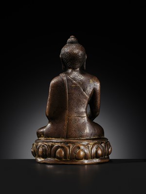 Lot 12 - AN INCSCRIBED GILT-COPPER FIGURE OF BUDDHA SHAKYAMUNI, NEPAL, LATE 13TH-EARLY 14TH CENTURY