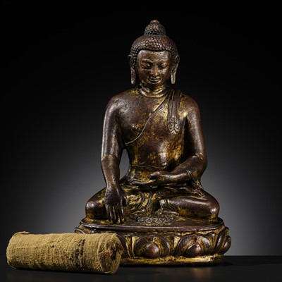 Lot 12 - AN INCSCRIBED GILT-COPPER FIGURE OF BUDDHA SHAKYAMUNI, NEPAL, LATE 13TH-EARLY 14TH CENTURY