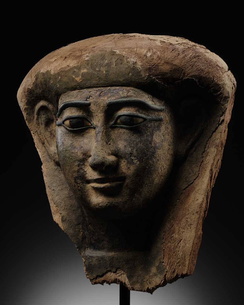 Lot 14 - A BRONZE AND LIMESTONE INLAID WOOD SARCOPHAGUS MASK, PTOLEMAIC PERIOD