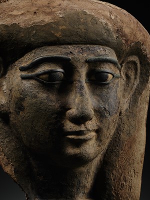 Lot 14 - A BRONZE AND LIMESTONE INLAID WOOD SARCOPHAGUS MASK, PTOLEMAIC PERIOD