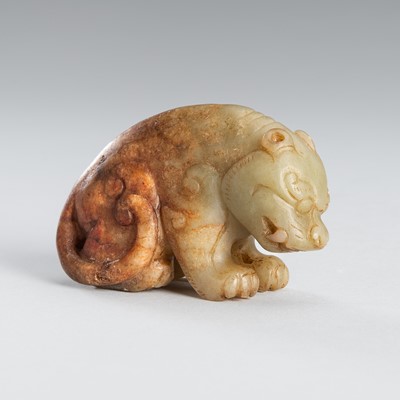 Lot 944 - A CELADON AND RUSSET JADE FIGURE OF A MYTHICAL BEAST, MING DYNASTY