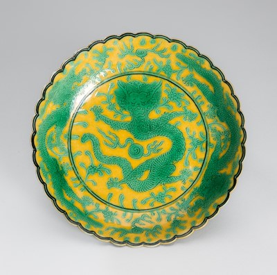 Lot 1225 - A SMALL YELLOW-GROUND AND GREEN-ENAMELED FOLIATE-RIMMED PORCELAIN 'DRAGON' DISH