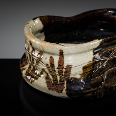 Lot 141 - A FINE KURO-ORIBE KUTSUGATA CHAWAN (TEA BOWL), EDO PERIOD, 17TH CENTURY