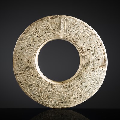 Lot 228 - AN IVORY WHITE JADE ‘DRAGON’ DISK, BI, WESTERN ZHOU DYNASTY