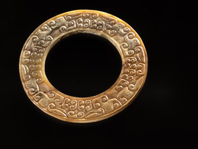 Lot 84 - A SMALL YELLOW JADE ‘DRAGONS’ RING, HUAN, EASTERN ZHOU, SPRING AND AUTUMN PERIOD