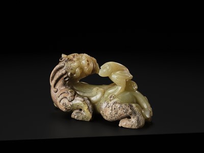 Lot 110 - A FINE CELADON AND BROWN JADE GROUP OF AN IMMORTAL RIDING A BIXIE, HAN DYNASTY