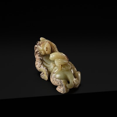 Lot 110 - A FINE CELADON AND BROWN JADE GROUP OF AN IMMORTAL RIDING A BIXIE, HAN DYNASTY