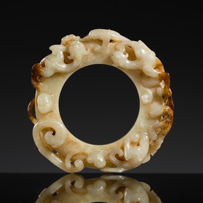 Lot 246 - A WHITE AND RUSSET JADE ‘DRAGON’ RING, HAN DYNASTY
