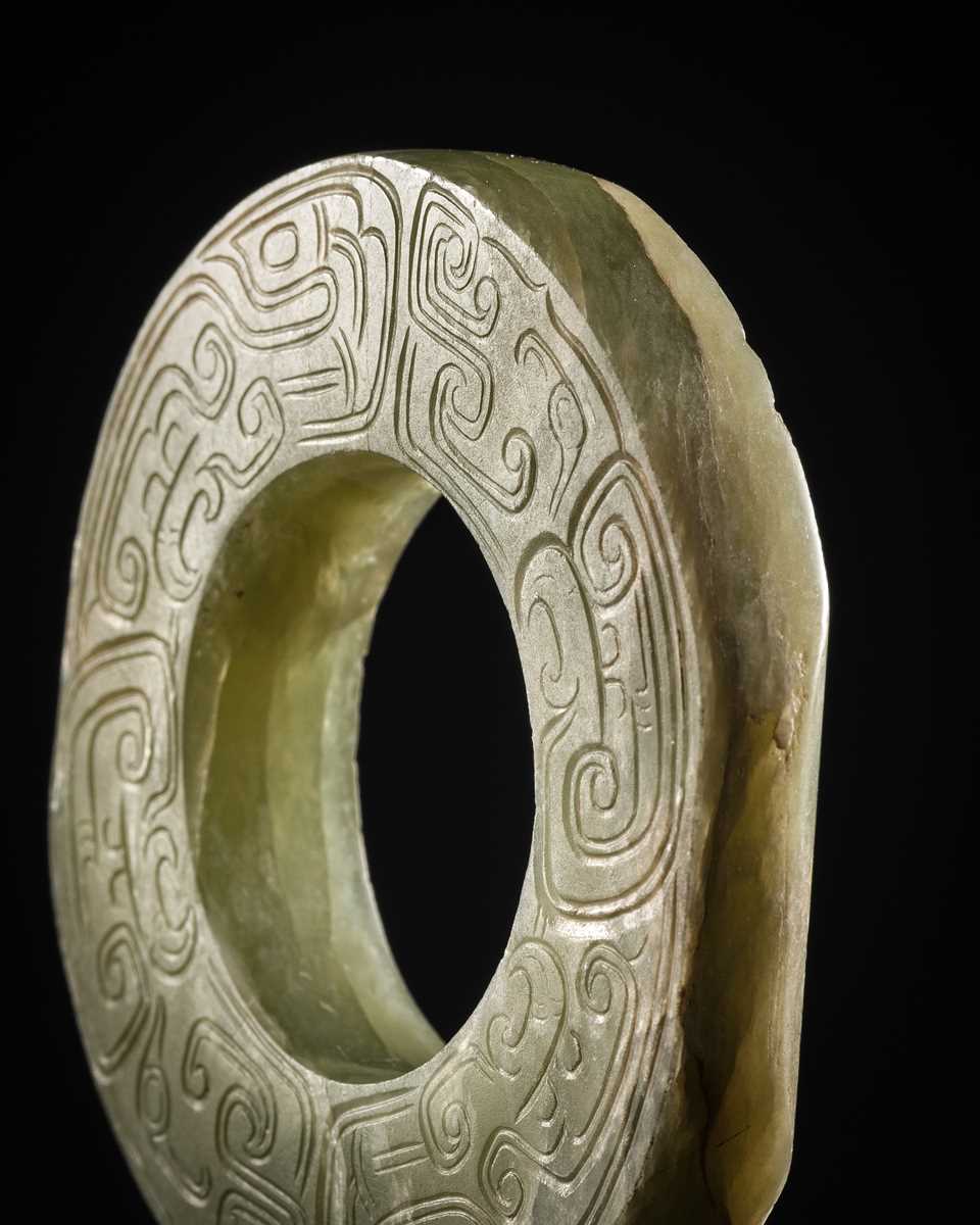 Lot 88 - A GREEN JADE ‘DRAGONS AND BIRDS’ RING-FORM PENDANT, EASTERN ZHOU DYNASTY