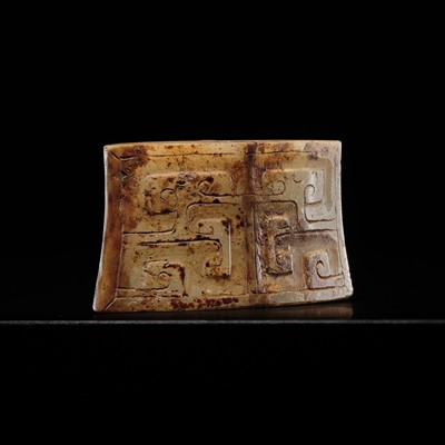 A WHITE AND RUSSET JADE ‘CLOUD-SCROLL’ SCABBARD CHAPE, WARRING STATES PERIOD TO WESTERN HAN DYNASTY