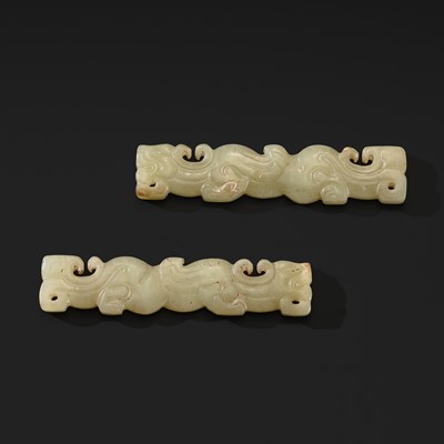 Lot 86 - A RARE PAIR OF PALE CELADON JADE ‘TIGER’ PENDANTS, WARRING STATES PERIOD