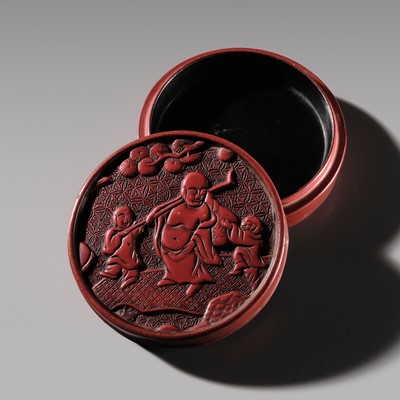 Lot 129 - A CINNABAR-LACQUER ‘BUDAI AND BOYS’ BOX AND COVER, MING DYNASTY