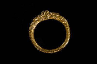 Lot 199 - A GILT-BRONZE ‘MAKARA’ BANGLE, SHOUZHUO, QING DYNASTY