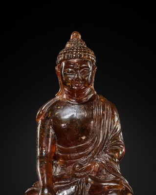 Lot 102 - A RARE AMBER FIGURE OF BUDDHA SHAKYAMUNI, EARLY QING DYNASTY