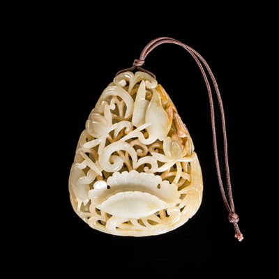 Lot 249 - A PALE CELADON AND RUSSET JADE ‘LOTUS AND CRANES’ RETICULATED PENDANT, 18TH-19TH CENTURY