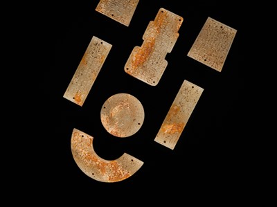 Lot 87 - A SET OF TWELVE WHITE AND RUSSET JADE ORNAMENTS, EASTERN ZHOU DYNASTY