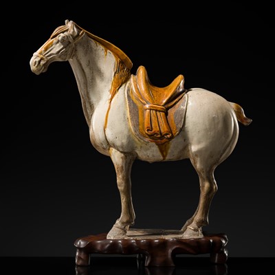 Lot 141 - AN AMBER AND CREAM-GLAZED POTTERY FIGURE OF A FERGHANA HORSE, TANG DYNASTY