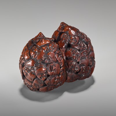 KOZAN: A RARE DOUBLE WALNUT NETSUKE WITH A MULTITUDE OF MASK