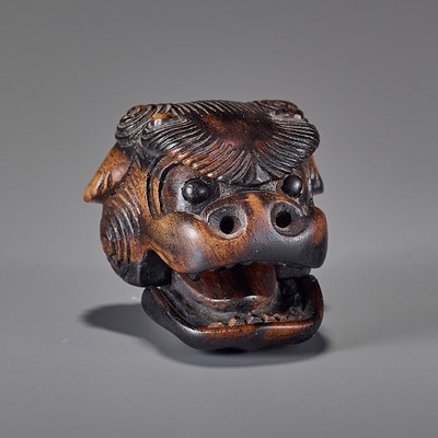A KUROGAKI WOOD NETSUKE OF A SHISHI MASK