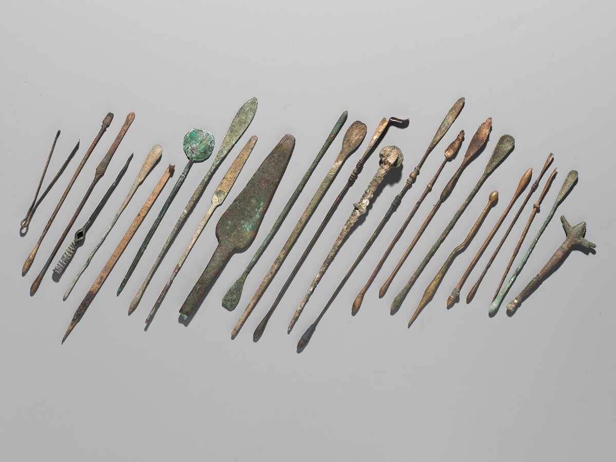 Lot 173 - A GROUP OF TWENTY-FOUR GREEK AND ROMAN BRONZE PINS, SPOONS AND TOOLS, 1ST MILLENNIUM AD AND EARLIER