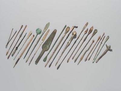 Lot 173 - A GROUP OF TWENTY-FOUR GREEK AND ROMAN BRONZE PINS, SPOONS AND TOOLS, 1ST MILLENNIUM AD AND EARLIER
