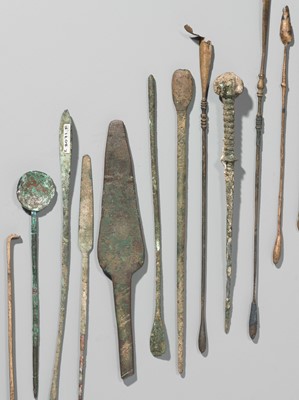 Lot 173 - A GROUP OF TWENTY-FOUR GREEK AND ROMAN BRONZE PINS, SPOONS AND TOOLS, 1ST MILLENNIUM AD AND EARLIER
