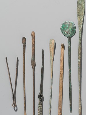 Lot 173 - A GROUP OF TWENTY-FOUR GREEK AND ROMAN BRONZE PINS, SPOONS AND TOOLS, 1ST MILLENNIUM AD AND EARLIER