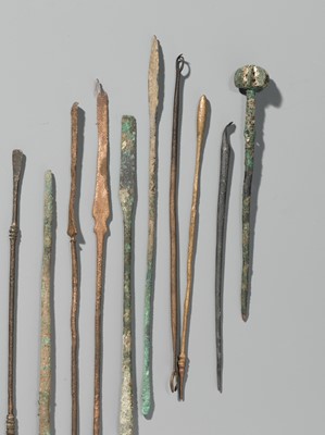 Lot 174 - A GROUP OF TWENTY-FIVE GREEK AND ROMAN BRONZE PINS, SPOONS AND TOOLS, 1ST MILLENNIUM AD AND EARLIER