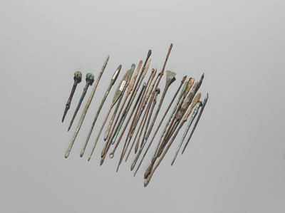 Lot 174 - A GROUP OF TWENTY-FIVE GREEK AND ROMAN BRONZE PINS, SPOONS AND TOOLS, 1ST MILLENNIUM AD AND EARLIER