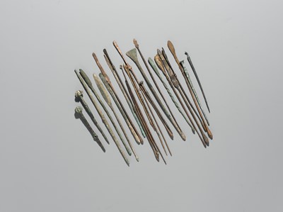 Lot 174 - A GROUP OF TWENTY-FIVE GREEK AND ROMAN BRONZE PINS, SPOONS AND TOOLS, 1ST MILLENNIUM AD AND EARLIER