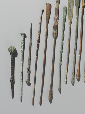 Lot 174 - A GROUP OF TWENTY-FIVE GREEK AND ROMAN BRONZE PINS, SPOONS AND TOOLS, 1ST MILLENNIUM AD AND EARLIER