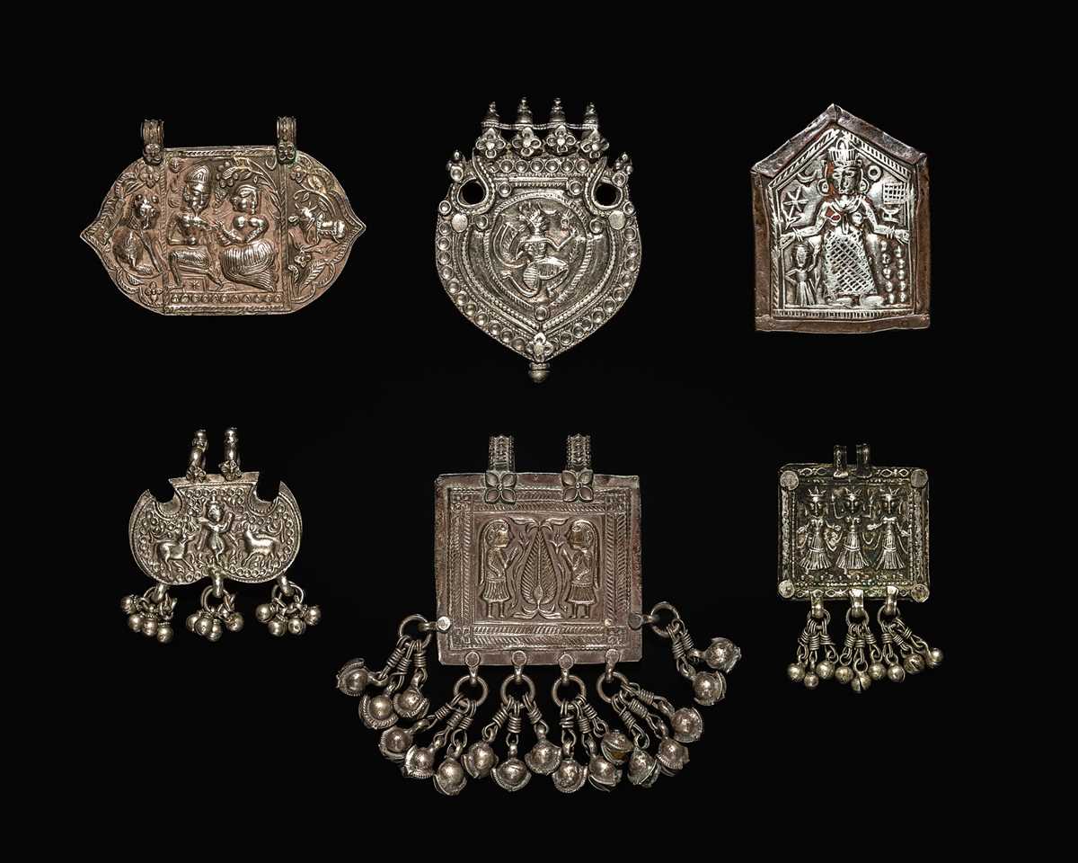 Lot 204 - A GROUP OF SIX SILVER REPOUSSÉ AMULET PENDANTS AND VOTIVE PLAQUE, HIMACHAL PRADESH AND RAJASTHAN