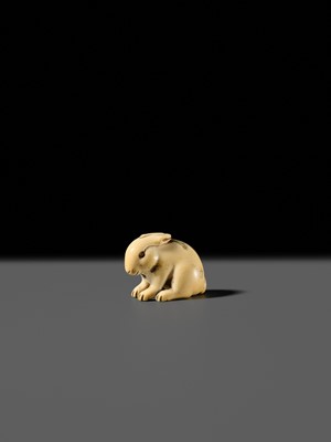 Lot 120 - RANICHI: A FINE IVORY NETSUKE OF A PIEBALD HARE WITH AMBER EYES